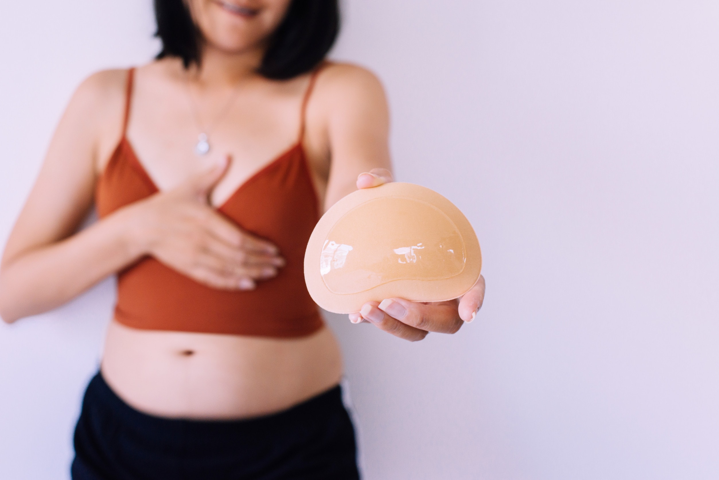 Quando è indicata la mastopessi con protesi? Un'immagine di una donna che considera le opzioni per la mastopessi con protesi.