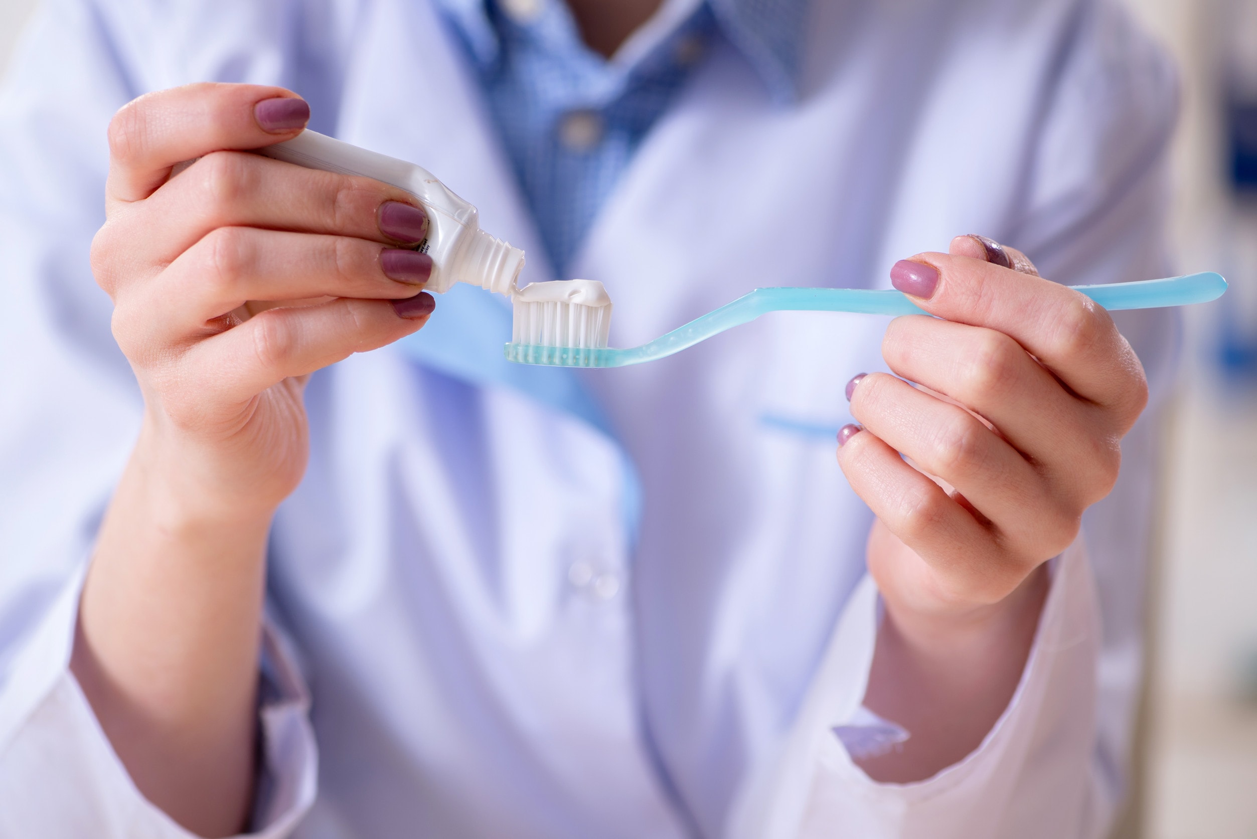 Igiene orale quotidiana con spazzolino e dentifricio, importante per la cura dell'impianto dentale singolo.